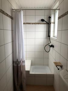 a shower with a white shower curtain in a bathroom at Haus Milaneva in Klotten +75 photos