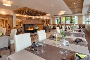 a dining room with tables and chairs and a fireplace at Alpenhof Lodge Almrose iii in Saltusio