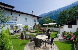 a patio with a table and chairs and a building at Alpenhof Lodge Almrose iii in Saltusio