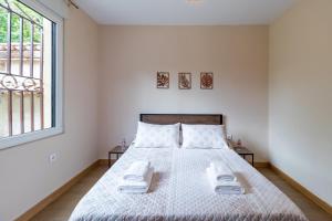 a white bedroom with a bed with two tables at Susurros de río in Ocejo