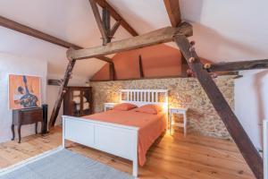 a bedroom with a bed and a stone wall at Maison Blousson, Longère gersoise in Malabat +24 photos