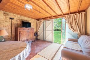 a bedroom with a bed and a sliding glass door at Maison Blousson, Longère gersoise in Malabat
