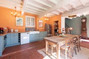a kitchen with blue cabinets and a wooden table at Maison Blousson, Longère gersoise in Malabat