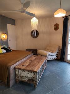 a bedroom with a bed and a table and a couch at Le Topaze in Grimaud