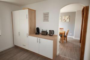 a kitchen with white cabinets and a counter with a microwave at Ferienhaus Eifelträume, Birresborn in Birresborn
