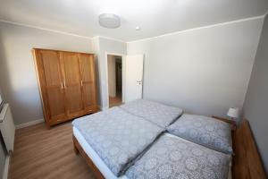 a bedroom with a bed and a wooden cabinet at Ferienhaus Eifelträume, Birresborn in Birresborn