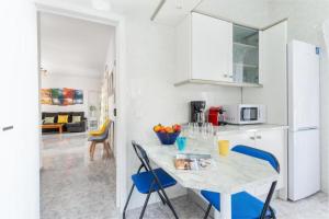 a kitchen with a table and blue chairs at Can Navarro in Llucmajor