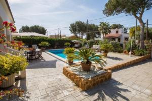 a swimming pool with potted plants in a yard at Can Navarro in Llucmajor