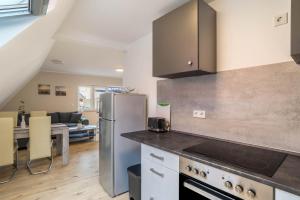 a kitchen with a stainless steel refrigerator and a living room at Unique Apartments Wiesloch in Wiesloch