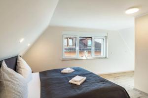 a bedroom with a bed with two towels on it at Unique Apartments Wiesloch in Wiesloch