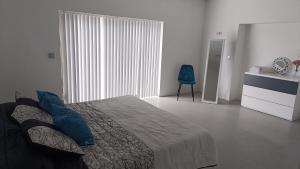 a bedroom with a bed and a blue chair at Bella Casa Total House in São Francisco +15 photos