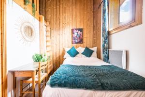 a bedroom with a bed and a table and a desk at Chalet Delphine Luxe, Ski aux pieds in Les Bruyères