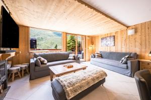 a living room with two couches and a table at Chalet Delphine Luxe, Ski aux pieds in Les Bruyères