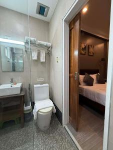 a bathroom with a toilet and a sink and a bed at Luxea Flexstay II - Spacious Duplex Home in San Francisco