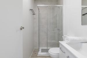 a white bathroom with a shower and a toilet at Apartamento Ajm in Barbate +12 photos
