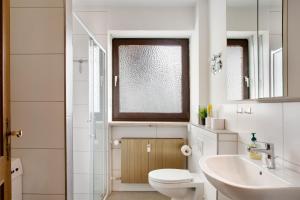 a white bathroom with a toilet and a sink at Weinberg in Zeilarn +17 photos