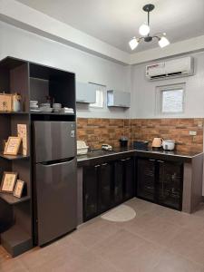 a kitchen with black cabinets and a stainless steel refrigerator at Luxea Flexstay II - Spacious Duplex Home in San Francisco