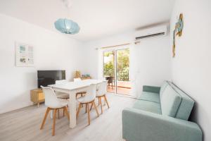 a living room with a table and a blue couch at Gran Sol Family 4 in Felanitx