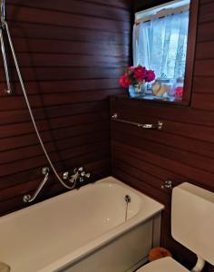 a bathroom with a tub and a toilet and a window at Schwarzwaldloge Zeitlos in Sasbachwalden