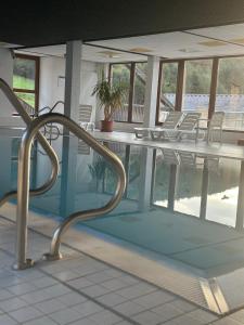 a swimming pool with chairs and a table at Schwarzwaldloge Zeitlos in Sasbachwalden