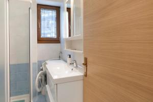 a bathroom with a sink and a toilet and a door at Super Mini Appartamento Lanzada in Lanzada +14 photos
