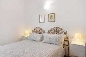 a bedroom with a bed with two night stands and two lamps at Super Mini Appartamento Lanzada in Lanzada