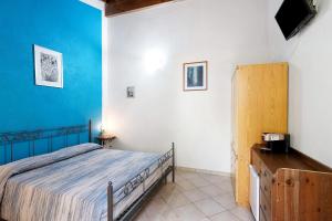 a bedroom with a bed and a blue wall at Agriturismo Green House in Santo Stefano al Mare