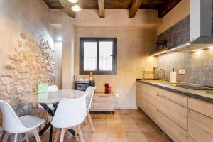 a kitchen with a table and white chairs at Entre Eras Apto Rural Los Vencejos in Ademuz