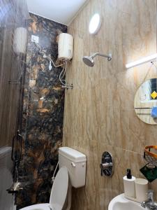 a bathroom with a toilet and a shower at Faaloon 102 in Chennai