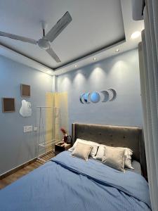 a bedroom with a blue bed with a ceiling at Faaloon 102 in Chennai