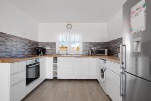 a kitchen with white cabinets and a refrigerator at Casa Helieta in Puerto del Rosario