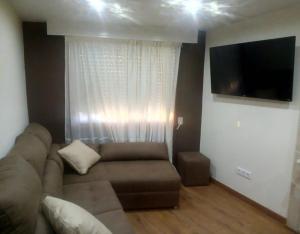 a living room with a couch and a flat screen tv at O Cantón in La Bola