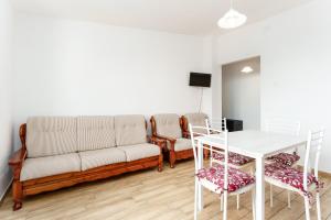 a living room with a couch and a table and chairs at Enjoy The Silence Flat in Orosei