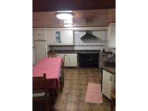 a kitchen with a table with a pink table cloth at O Cantón in La Bola