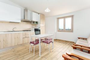 a kitchen with a white table and chairs at Enjoy The Silence Flat in Orosei