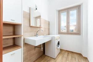 a bathroom with a sink and a washing machine at Enjoy The Silence Flat in Orosei +16 photos