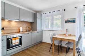 a kitchen with white cabinets and a wooden table at Apartment Jegle in Salem