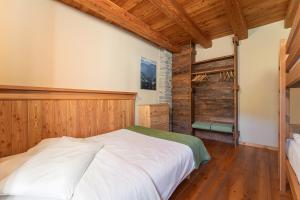 a bedroom with a white bed and wooden walls at Civico 12 in Marmora