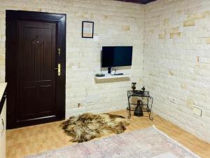 a room with a television and a door and a rug at Siera Home in Berat