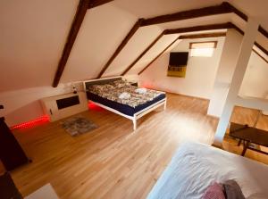 an attic room with a bed and a tv at Kuća za odmor Bećarsko utočište Vinkovci in Vinkovci