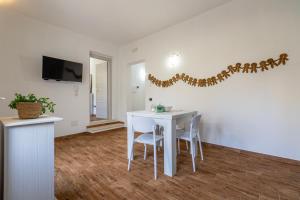 a white dining room with a white table and chairs at Casa Rinascita con Piscina Privata in Nulvi