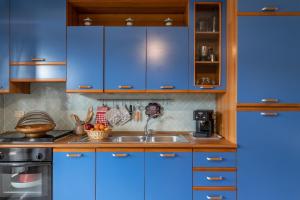 a kitchen with blue cabinets and a sink at Simona in Fetovaia +19 photos