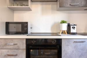 a kitchen with a microwave and a stove at Casa Rinascita con Piscina Privata in Nulvi