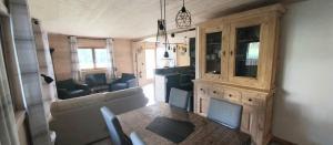 a living room with a couch and a dining room table at Gite Cairn, Rez De Chalet in Faverges