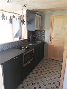 a kitchen with a black counter top and a sink at Gite Cairn, Rez De Chalet in Faverges