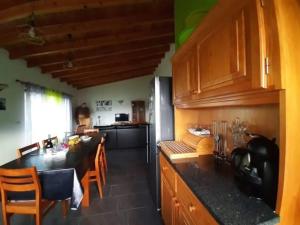 a kitchen with a table and a dining room at Ocean Melody in Canto da Areia