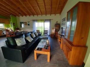 a living room with a black couch and a table at Ocean Melody in Canto da Areia
