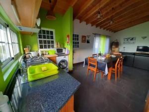 a kitchen with a table and a kitchen with green walls at Ocean Melody in Canto da Areia
