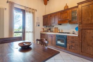 a kitchen with wooden cabinets and a table with a bowl on it at Villette di Contignano in Radicofani