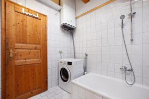 a bathroom with a washing machine and a wooden door at Schnitzer Ferienwohnung in Görisried +12 photos